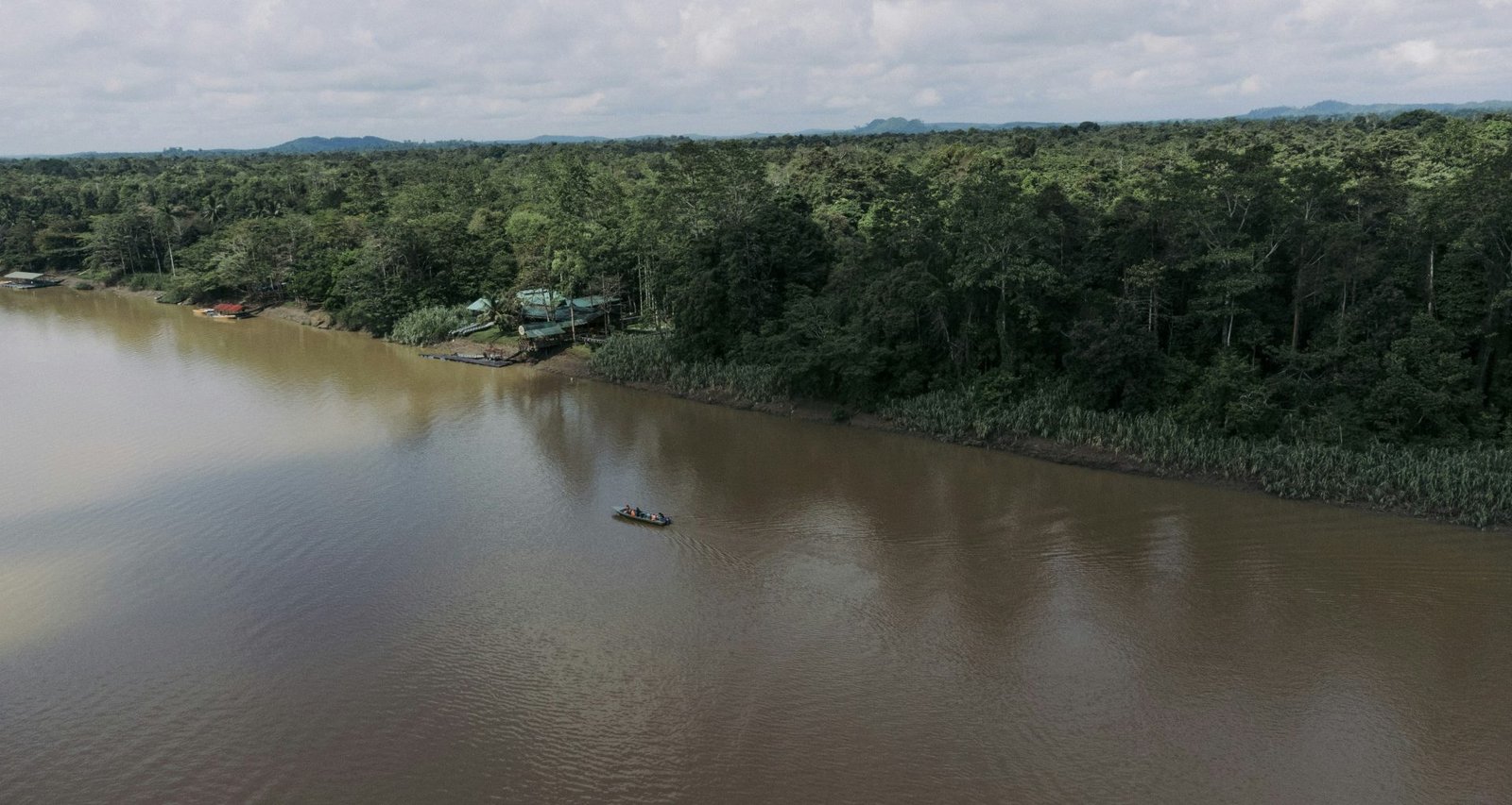 ein-boot-das-auf-einem-see-schwimmt-umgeben-von-wald-8DPmDpFfisw