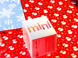 ein-karton-mit-sussigkeiten-auf-einem-mit-geschenkpapier-bedeckten-tisch-nRS4RcpLCto