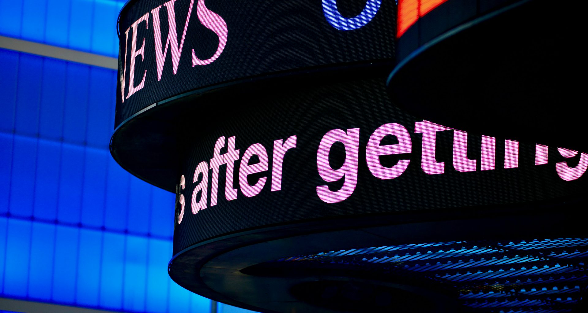 nahaufnahme-eines-schildes-mit-einem-gebaude-im-hintergrund-2oyHDz6LW1w