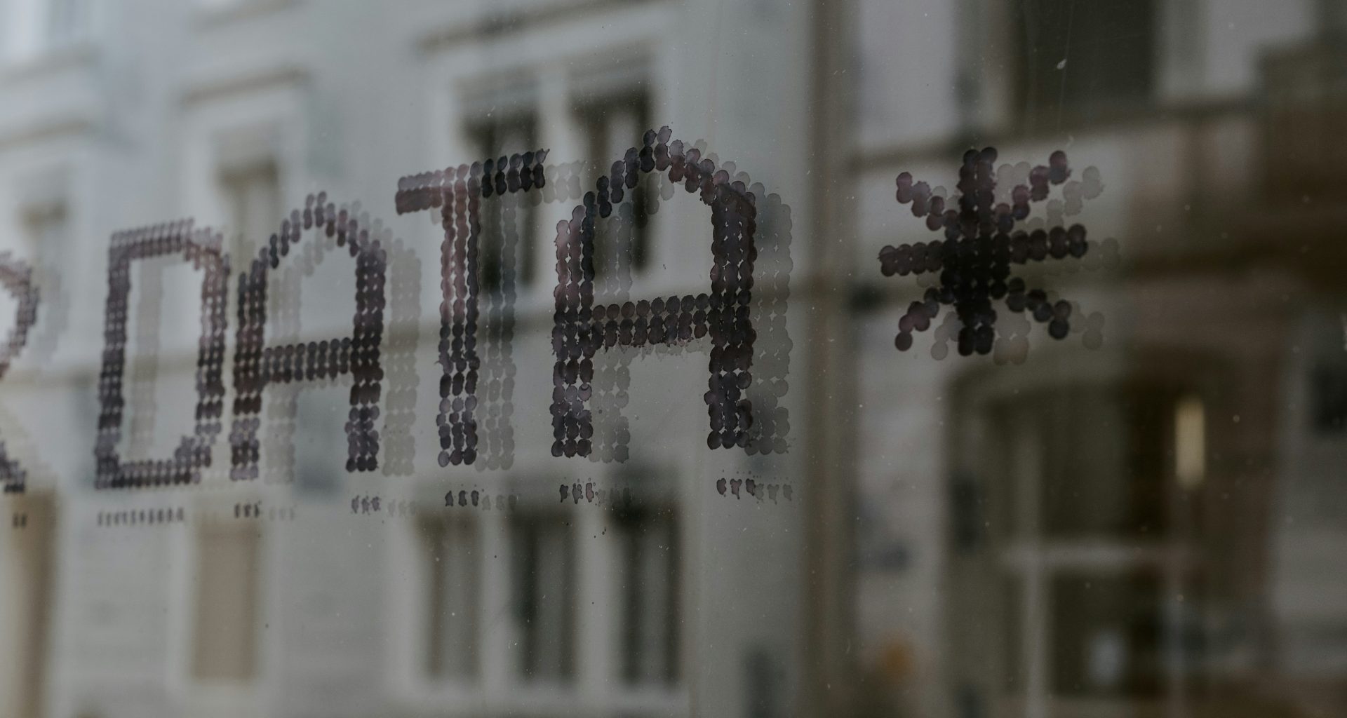 nahaufnahme-eines-fensters-mit-einem-gebaude-im-hintergrund-fyeOxvYvIyY