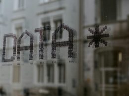 nahaufnahme-eines-fensters-mit-einem-gebaude-im-hintergrund-fyeOxvYvIyY