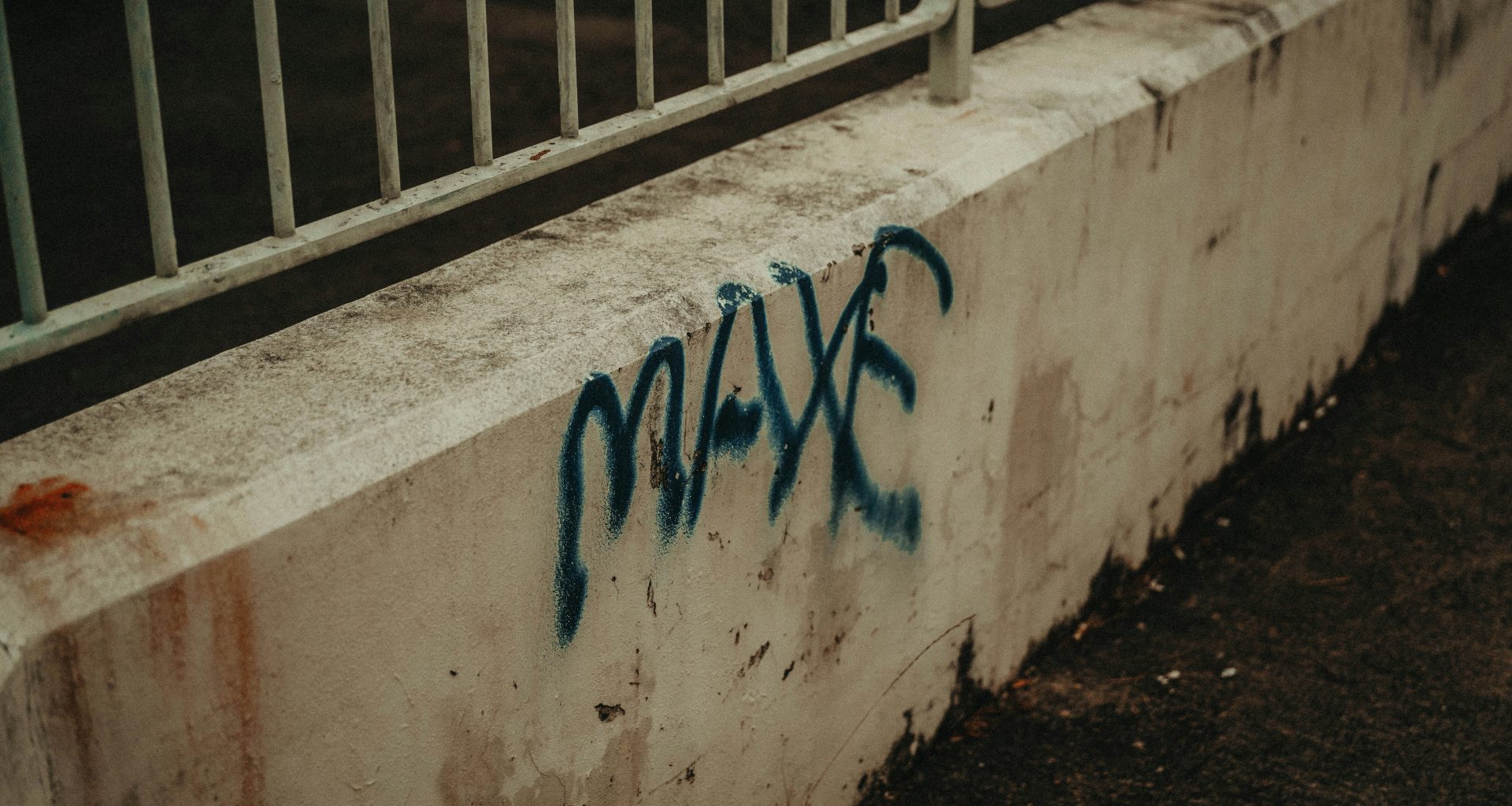 eine-betonwand-mit-blauem-graffiti-darauf-bUjuoCEIw5o