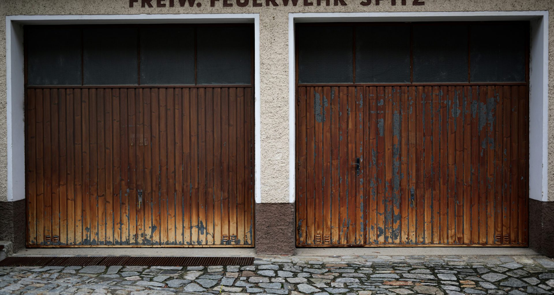 ein-paar-braune-garagentore-die-nebeneinander-sitzen-jwno9qq__IA