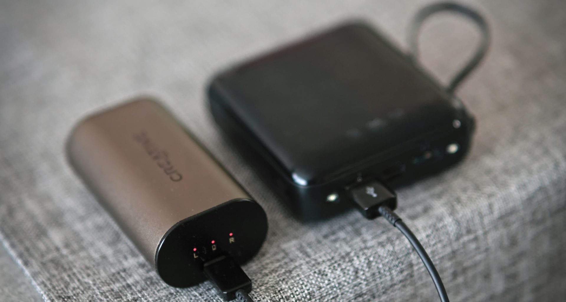 ein-paar-elektronische-gerate-die-auf-einem-bett-sitzen-8q8icoKEJIY