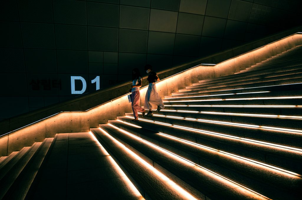 ein-paar-leute-die-eine-treppe-hinuntergehen-LoZaQLMc7N0