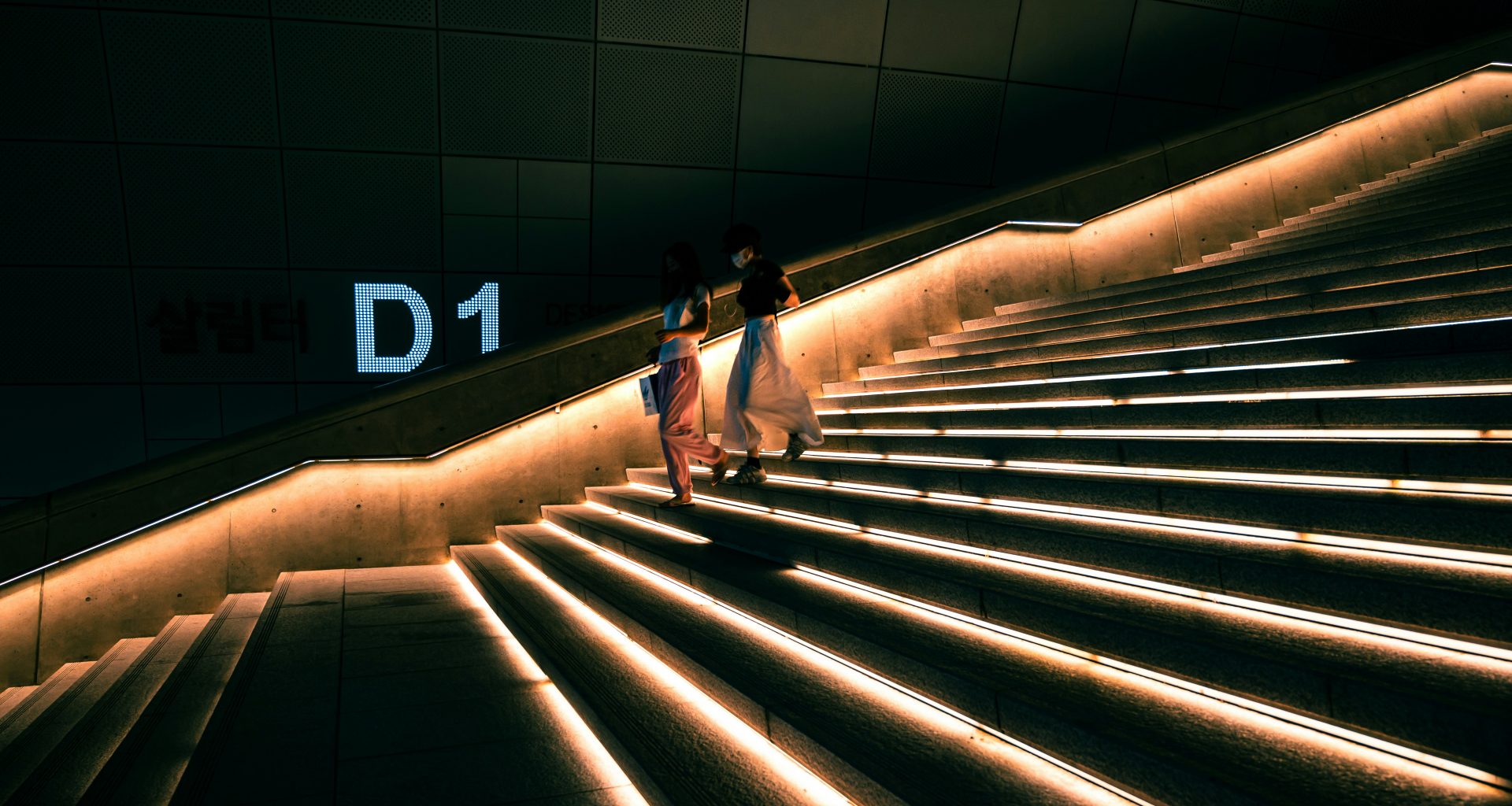 ein-paar-leute-die-eine-treppe-hinuntergehen-LoZaQLMc7N0