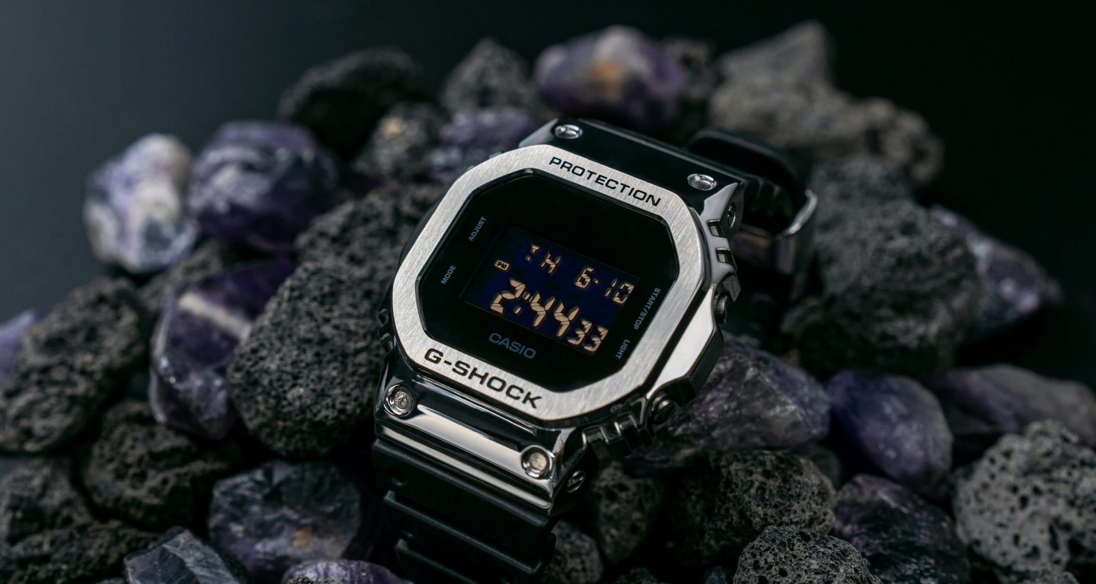 eine-digitaluhr-die-auf-einem-steinhaufen-sitzt-2VVTR-SOIPk