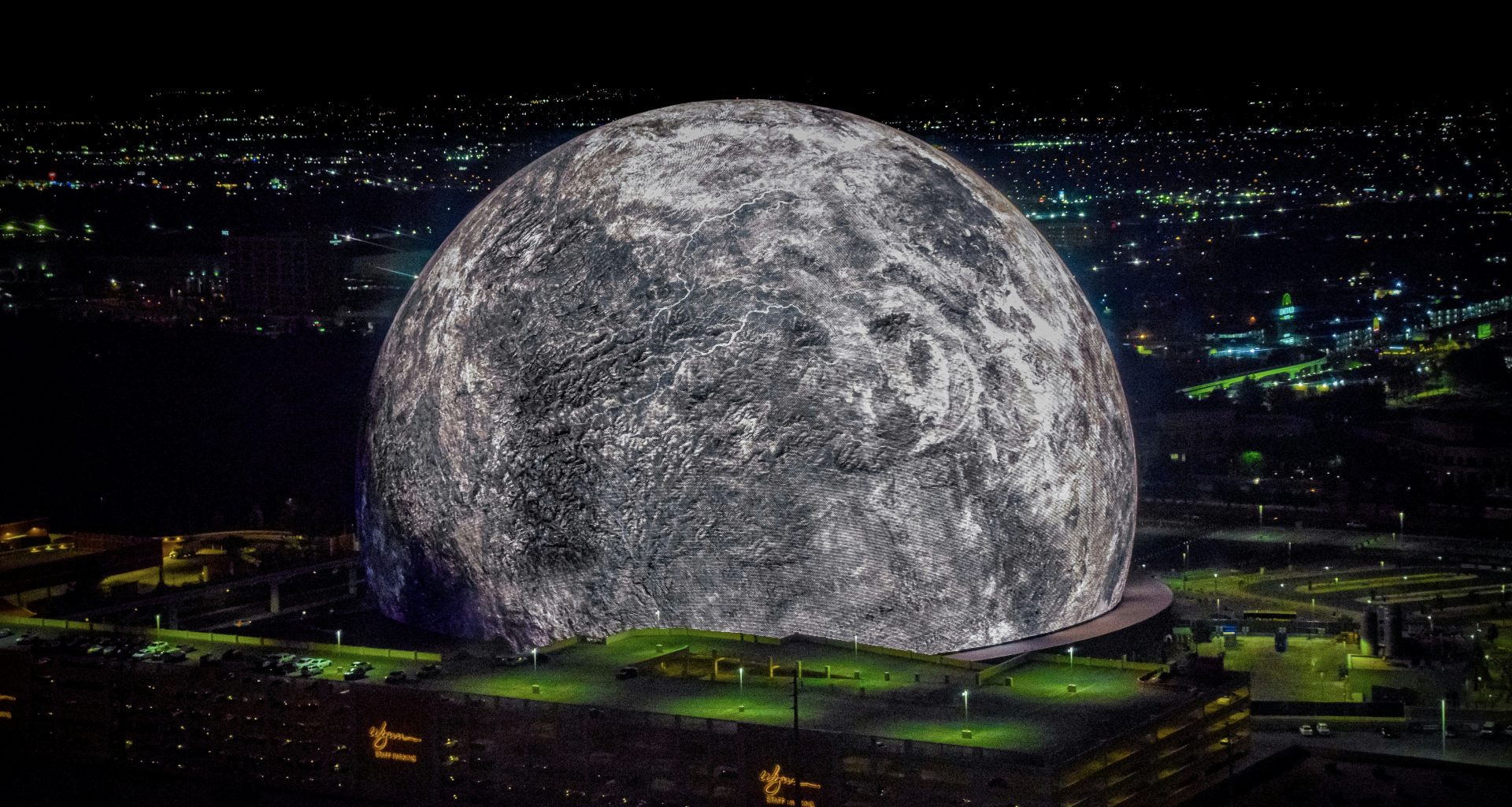ein-grosser-mond-uber-einer-stadt-bei-nacht-UOFTcVqy0BM