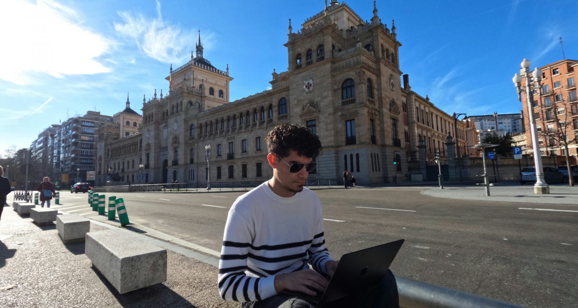 ein-mann-der-auf-einer-bank-sitzt-und-einen-laptop-benutzt-N0WmVjYrcyQ