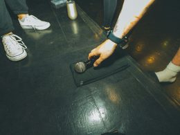 eine-person-die-ein-mikrofon-auf-einem-schwarzen-boden-halt-Ngl4R1V8ByE