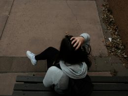 eine-person-die-auf-einer-bank-auf-einem-burgersteig-sitzt-guefe7-LVZY