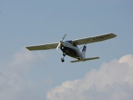 ein-kleines-flugzeug-das-durch-einen-wolkenverhangenen-blauen-himmel-fliegt-5lY0pl27kHM