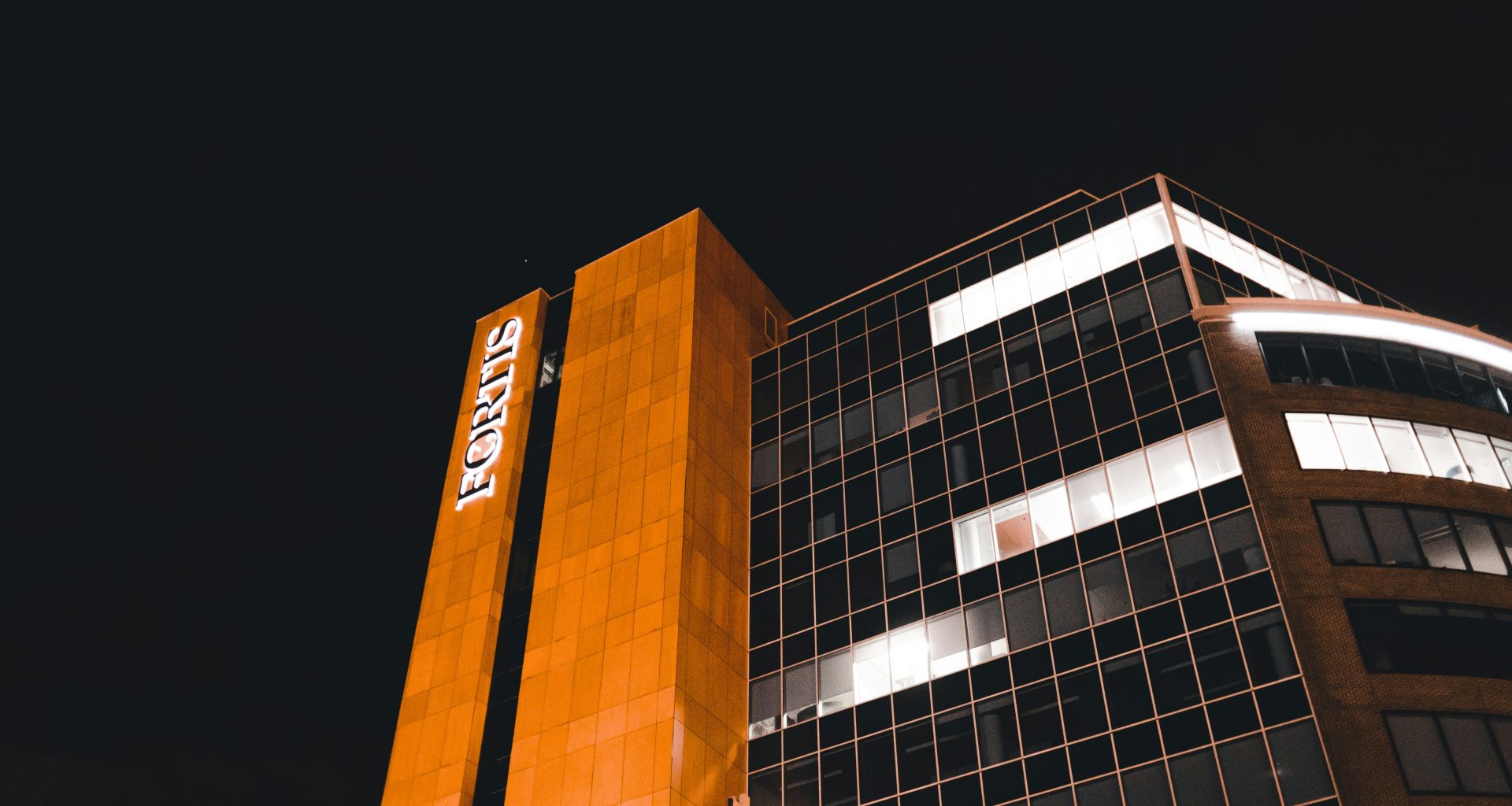 ein-hohes-gebaude-mit-einem-beleuchteten-schild-an-der-seite-3j4t4OdYMvU