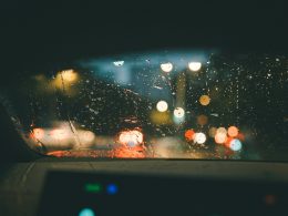 blick-auf-eine-regenbedeckte-windschutzscheibe-aus-dem-inneren-eines-autos-R-9w8yLlZdg