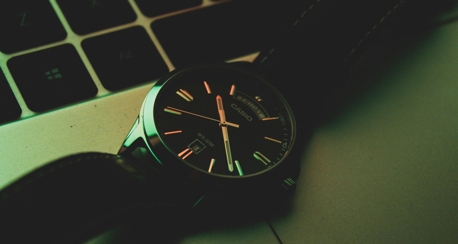 eine-uhr-die-auf-einem-laptop-sitzt-M_XMwkXRwU0