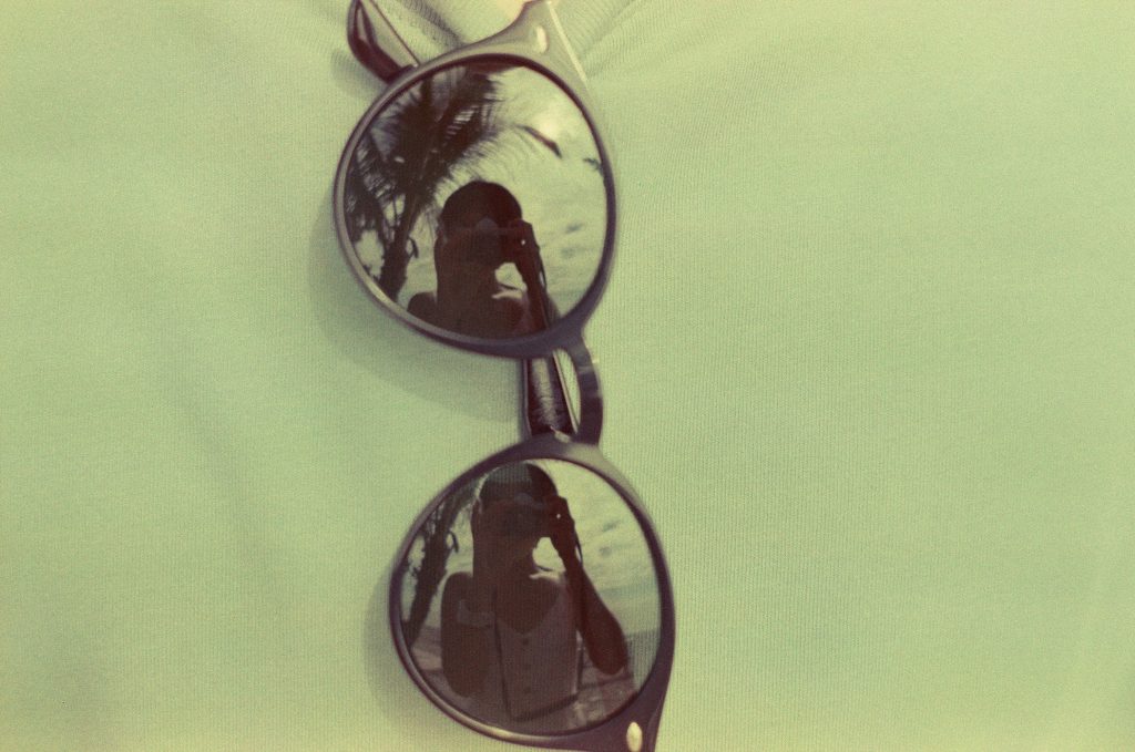 braun-gerahmte-sonnenbrille-auf-gelbem-textil-Upe_ZECIQX8