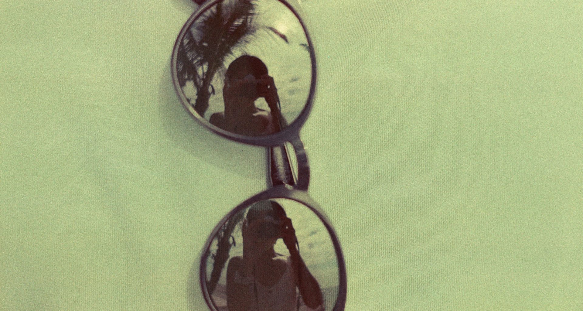 braun-gerahmte-sonnenbrille-auf-gelbem-textil-Upe_ZECIQX8