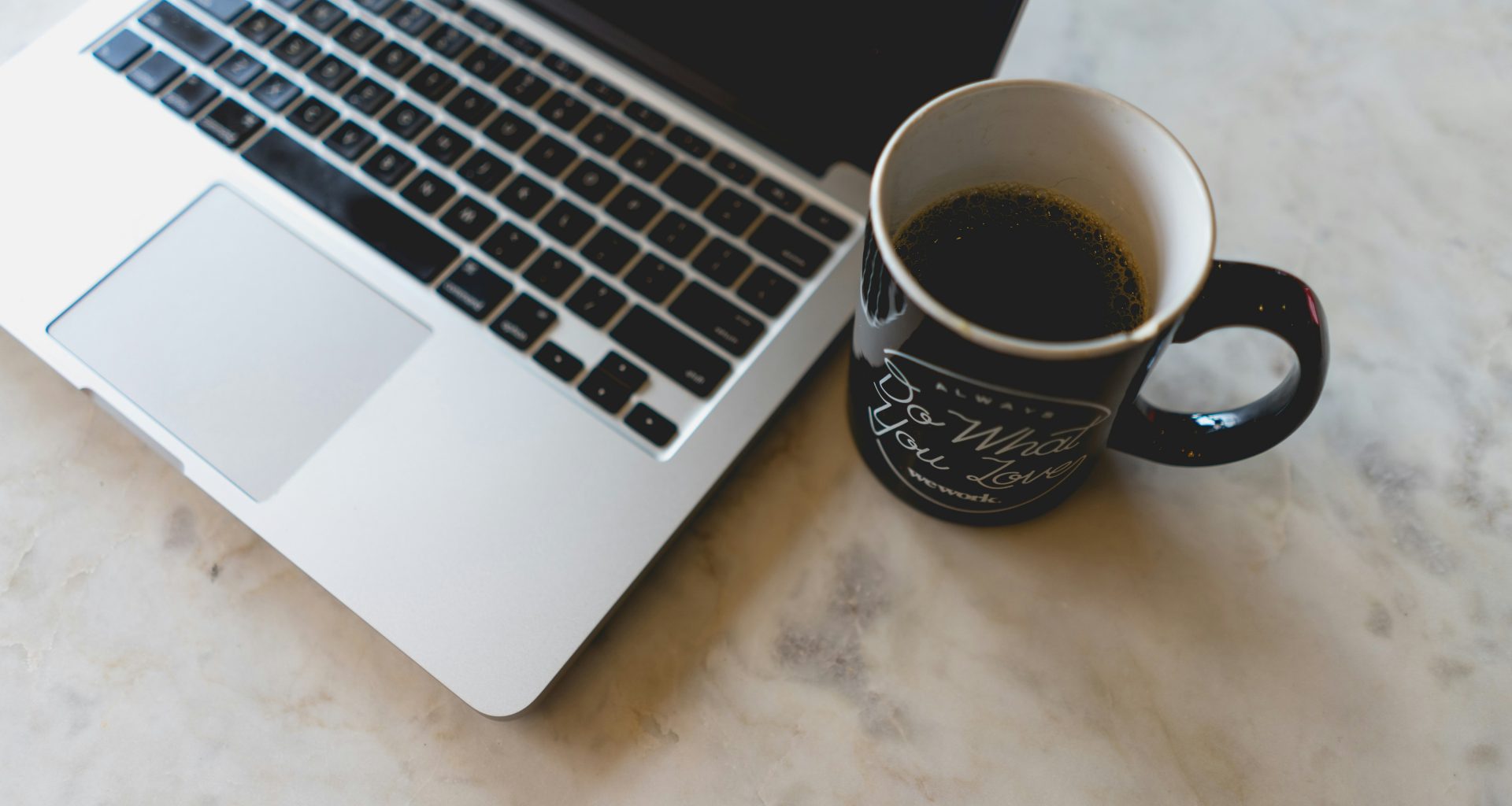 kaffee-im-becher-neben-macbook-pro-NneNzn0vs44