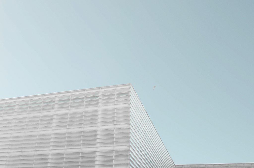 graues-betongebaude-unter-strahlend-blauem-himmel-cqK6Ysfhhb0