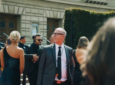 mann-im-schwarzen-anzug-steht-neben-frau-in-schwarzem-armellosem-kleid-86FS7rESSg0