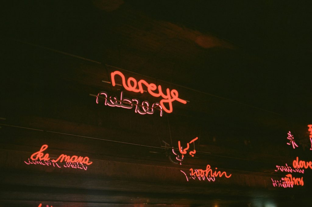 neonschilder-an-der-seite-eines-gebaudes-bei-nacht-hYtGeoox2VQ