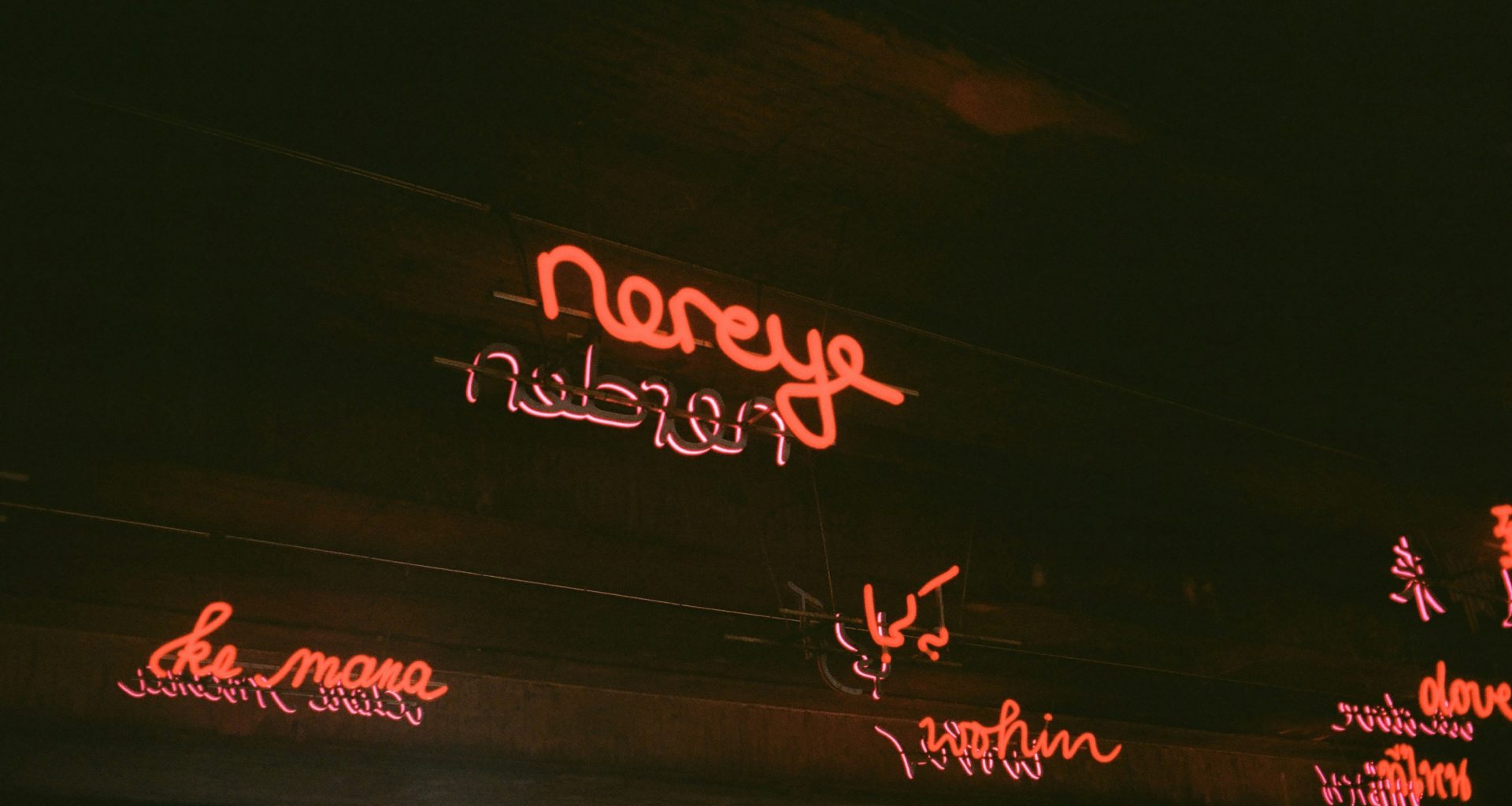 neonschilder-an-der-seite-eines-gebaudes-bei-nacht-hYtGeoox2VQ