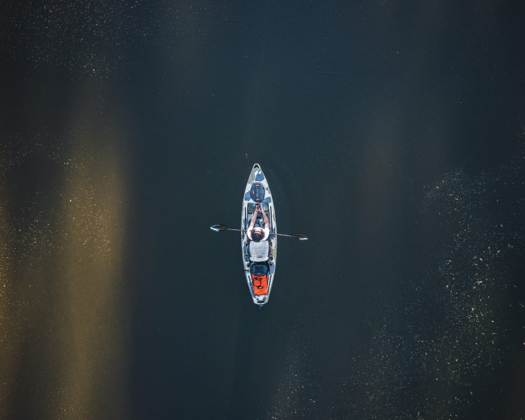 person-die-tagsuber-auf-einem-weissen-und-blauen-boot-auf-dem-wasser-fahrt-F1hiWf_76Q0