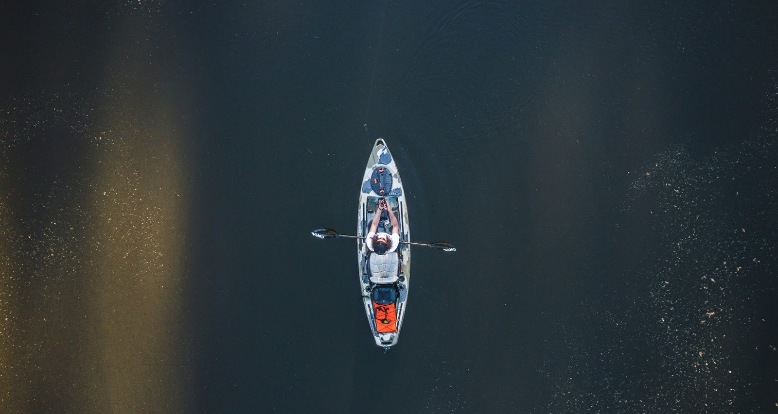 person-die-tagsuber-auf-einem-weissen-und-blauen-boot-auf-dem-wasser-fahrt-F1hiWf_76Q0