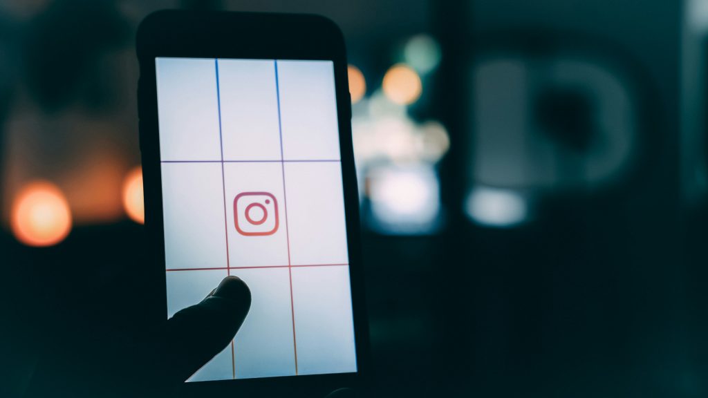 person-die-smartphone-mit-instagram-logo-screengrab-bokeh-fotografie-verwendet-Fs1hfkNOGsQ