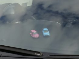 zwei-kleine-spielzeugautos-auf-einem-armaturenbrett-5YYIwej2HLo