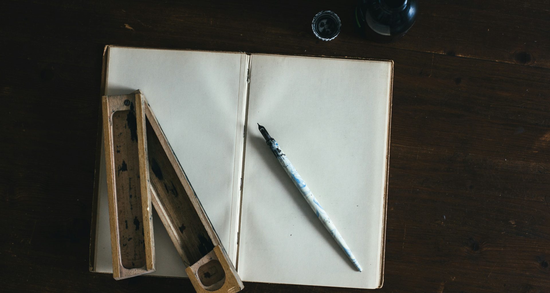 weisser-fullfederhalter-auf-weissem-offenem-buch-9P7WD1dU5VQ