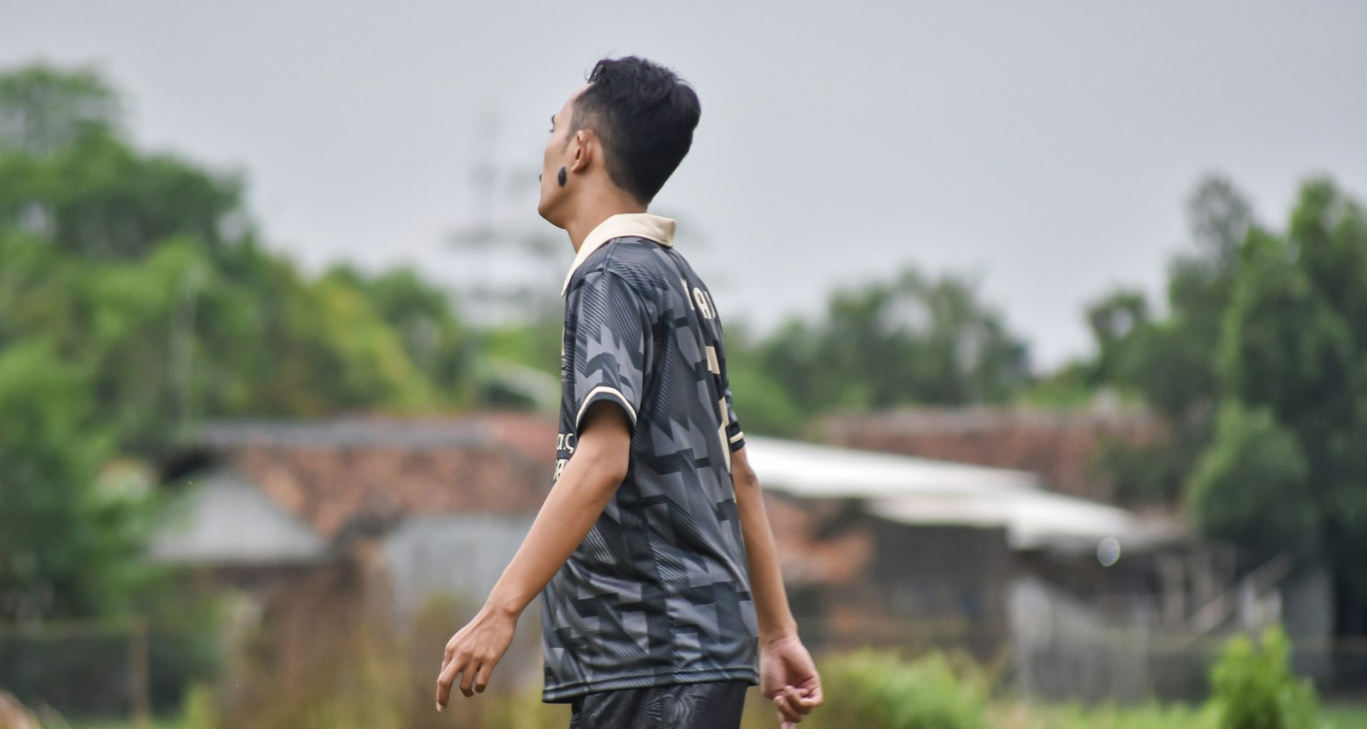 junger-mann-im-fussballtrikot-schaut-in-den-himmel-KLLmR_LLH2Q