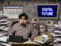 Frustrierter Büroarbeiter im alten Büro mit Kabelsalat, alten Computern und Papierstapeln, während eine Präsentation die digitale Zukunft ankündigt.