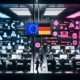 Futuristischer Kontrollraum mit Menschen, die an Laptops arbeiten, und leuchtenden Monitoren mit KI-Algorithmen, Datenschutz-Icons, Paragrafen-Symbolen und Warnungen. Über alles ragen EU-Sternenbanner und deutsche Gesetzessymbole.