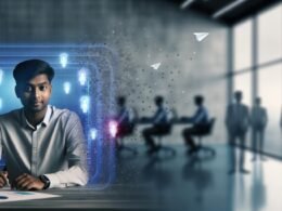 Junger Marketer an Schreibtisch mit holografischen Datenvisualisierungen und KI-Icons in einer modernen, blau-grauen Bürolandschaft; im Hintergrund Mitarbeitende in Code und kreative Symbole.