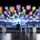 Modernes Büro mit Laptops und bunten Daten-Dashboards, visuelle Datenflüsse zwischen Software-Icons wie Salesforce und HubSpot. Marketer arbeitet am zentralen Dashboard, entfernt Datenmüll.