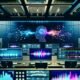 Modernes Tonstudio mit futuristischen KIs, smarte Lautsprecher und große Bildschirme zeigen TTS- und Voice-Cloning-Oberflächen, leuchtende Wellenformen und Dashboards; keine Menschen anwesend.