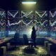 Gritty Workspace mit mehreren Dashboards, Conversion-Statistiken und Marketer in Hoodie, der Charts analysiert