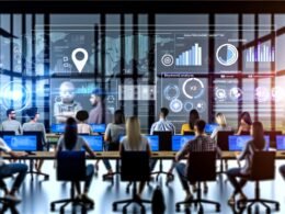 Dynamische Büro-Szene mit diversen Menschen vor großen Monitoren voller Datenvisualisierungen und KPI-Dashboards, im Hintergrund dezente Hologramme und KI-Symbole.