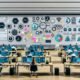 Content-Team arbeitet konzentriert im modernen Großraumbüro mit digitalen Tools, großen Monitoren, KI-Icons und kreativen Arbeitsmethoden.