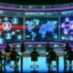 Futuristische Szene: Marketer und Tech-Spezialisten analysieren Social-Media-Daten an Multiscreen-Wänden mit KI-Diagrammen, leuchtender Glaswand und Hightech-Neonambiente.