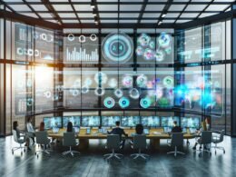 Junges Marketingteam in einem futuristischen, offenen Office analysiert Daten auf großen, transparenten Bildschirmen mit Unterstützung einer schwebenden KI.