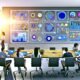 Stylisches Marketingbüro mit großem interaktivem Dashboard und professionellen Mitarbeitern, die Echtzeit-Marketingdaten von verschiedenen Plattformen analysieren.