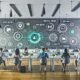 Modernes Marketingbüro mit digitalem Dashboard, diversen Marketingprofis an Laptops, und grafischer Darstellung von Content-Erstellung, Omnichannel-Publishing, Deep Analytics, Asset-Management sowie KI-Integrationen.