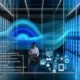 Dynamische Darstellung eines durchsichtigen Serverraums mit leuchtenden Datenströmen, verbundenen Geräten, Consent-Bannern und einer Person mit Laptop vor Analytics-Displays.