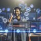 Futuristischer Arbeitsplatz mit digitalen Dashboards, Marketer mit Kopfhörern am Mikrofon, und Symbolen für Automation und Tracking.