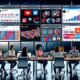 Digitales, diverses Marketing-Team an modernen Arbeitsplätzen mit geöffneten Social-Media-Oberflächen, Content-Kalender und Analytics-Charts.