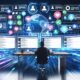 Moderne Leitstelle mit futuristischem Schreibtisch, zentraler Person vor mehreren Monitoren, schwebenden User-Avataren und digitalen Netzwerk-Elementen