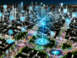 Futuristische Großstadt bei Nacht mit leuchtenden Datenströmen, holographischen Interfaces, autonomen Fahrzeugen, KI- und Cloud-Symbolen sowie moderner urbaner Infrastruktur.