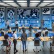 Futuristisches Open-Space-Marketingbüro 2025 mit diversen Teammitgliedern vor Dashboards, Whiteboards und vernetzten KI-Systemen, die Datenströme visualisieren.